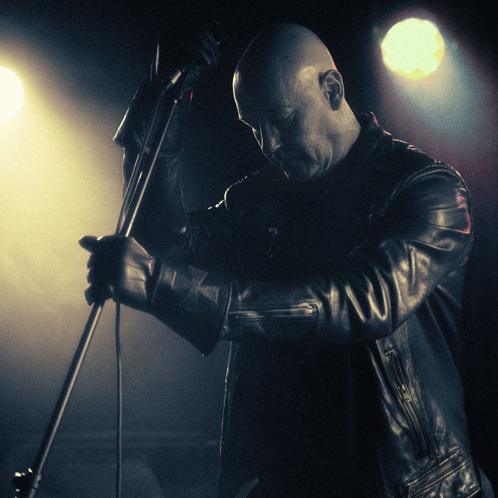 Host performing in a dark, atmospheric setting